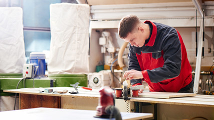Process of production and manufacture of wooden furniture in furniture factory. Worker carpenter...
