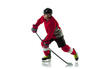 Obraz premium Leader. Male hockey player with the stick on ice court and white background. Sportsman wearing equipment and helmet practicing. Concept of sport, healthy lifestyle, motion, movement, action.