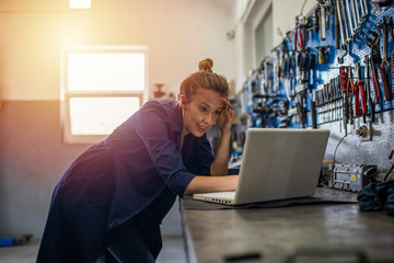 Female mechanic with laptop. Workshop owner doing quality control on laptop. Young female mechanic with laptop. Creativity is a process. Beautiful woman mechanic