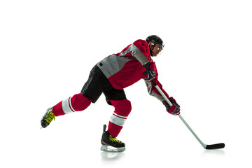 Fototapeta premium On the run. Male hockey player with the stick on ice court and white background. Sportsman wearing equipment and helmet practicing. Concept of sport, healthy lifestyle, motion, movement, action.