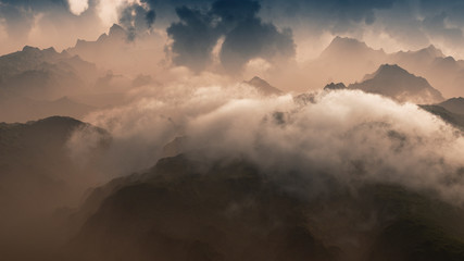 Clouds over rugged mountain landscape. Aerial view.