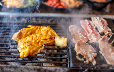 BBQ chicken and pork on grill at restaurant