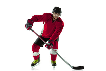 Obraz premium Scoring a goal. Male hockey player with the stick on ice court and white background. Sportsman wearing equipment and helmet practicing. Concept of sport, healthy lifestyle, motion, movement, action.