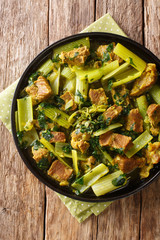 Khoresh Karafs is a healthy and flavorful food made with stew meat, celery, mint, parsley and Persian lemons closeup in the plate. Vertical top view