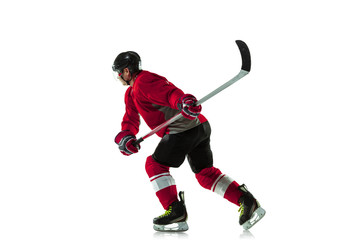 Fototapeta premium Scoring a goal. Male hockey player with the stick on ice court and white background. Sportsman wearing equipment and helmet practicing. Concept of sport, healthy lifestyle, motion, movement, action.