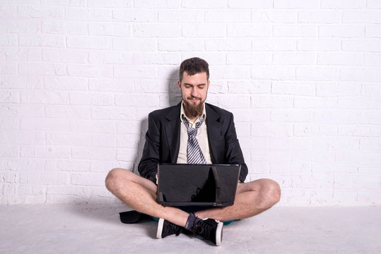 Business man in a jacket and shorts working on the laptop remotely. Workaholic working on weekends.
