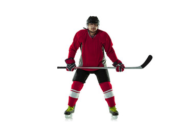 Activity. Male hockey player with the stick on ice court and white background. Sportsman wearing equipment and helmet practicing. Concept of sport, healthy lifestyle, motion, movement, action.