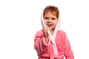 little happy girl with an electric toothbrush in pink bathrobe isolated on a white background