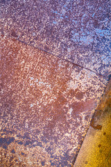 two sheets of rusty metal welded together lie on each other.