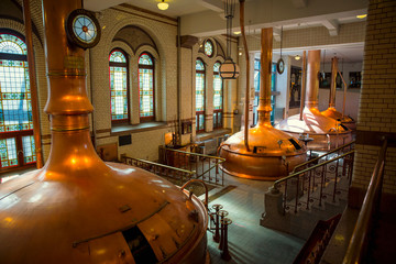 The interior of an old brewery with large copper vats