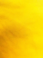 Texture background of yellow cotton fabric with wrinkles.