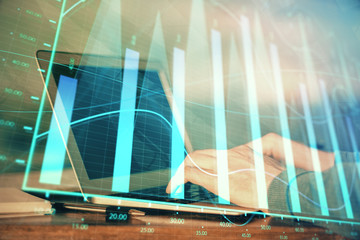 Double exposure of stock market graph with man working on laptop on background. Concept of financial analysis.