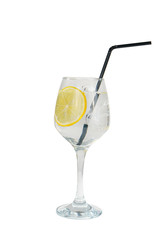 Transparent cocktail, refreshing water in a tall glass with ice cubes, straw, and a round slice of lemon, side view, isolated white background. Drink for the menu restaurant, bar, cafe