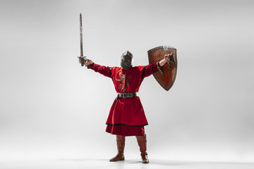 Brave armored knight with professional weapon fighting isolated on white studio background....