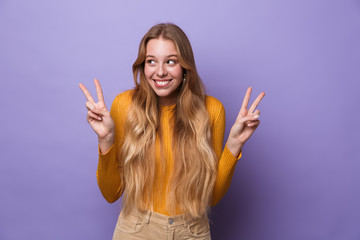 Photo of cheerful young woman laughing and gesturing peace sign