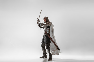 Brave armored knight with professional weapon fighting isolated on white studio background....