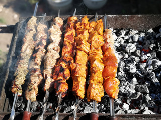 Grilling shashlik on barbecue grill. Sunny summer day.