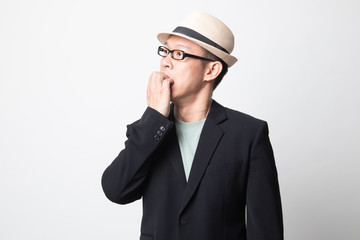 Unsure hesitant nervous adult asian man  biting his fingernails.