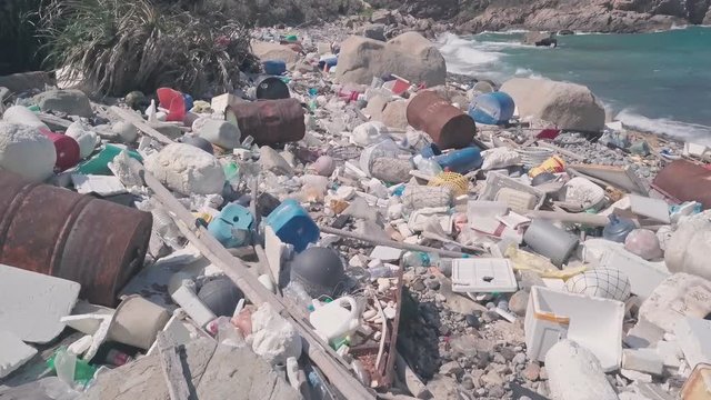 Environmental destruction caused by beach covered in plastic and rubbish causing climate change in Hong Kong. Aerial drone view