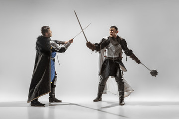 Brave armored knights with professional weapon fighting isolated on white studio background....