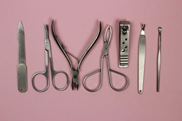 Set of manicure and pedicure tools on pink background