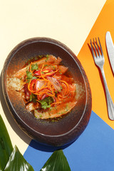 exquisite restaurant dish on a flat plate on a colored background. Restaurant serving. View from above