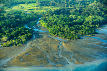 River in tropic Costa Rica, Corcovado NP. Lakes and rivers, view from airplane. Green grass in...
