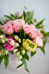 Bright bouquet with roses, eustoma and alstroemeria in white vase. Bouquet on soft blue background