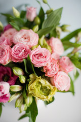 Bright bouquet with roses, eustoma and alstroemeria in white vase. Bouquet on soft blue background