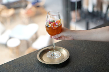 Iced black coffee with fresh juice - A glass of cold brew coffee with mandarin orange, ginger, lemon and mixed fruit on blurred background, Perfect drink for summer time.