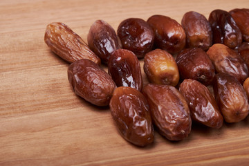 dried date fruit in bowl on wooden table background.