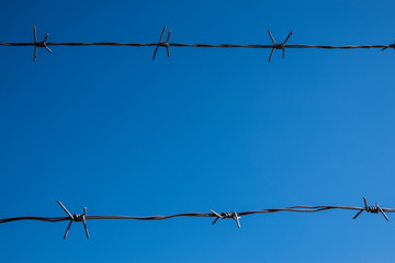 barbed wire on background of blue sky