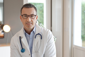 Portrait of doctor posing in office, looking at camera