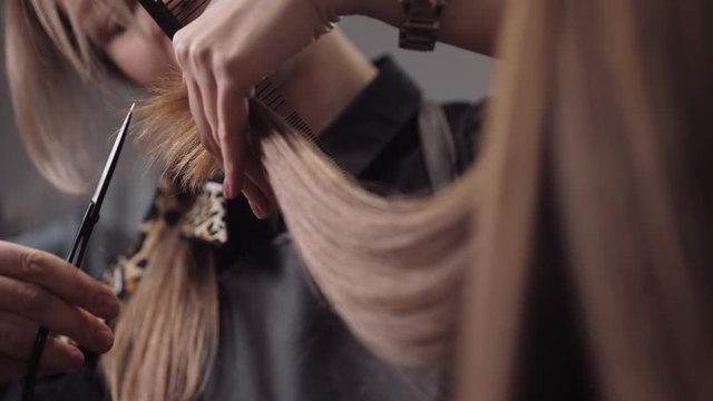 Hair salon girl haircuts. Close up 4K slow motion