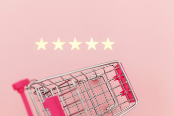 Small supermarket grocery push cart for shopping toy with wheels and 5 stars rating isolated on...