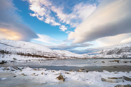 winterlandscape with dramatic sky on Kvaloeya Island near Tromsoe in northern Norway, landscape 