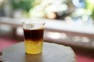 Iced coffee with orange - A glass of espresso shot mixed with orange juice and craft soda on blurred background and copy space, Perfect drink for summer time.