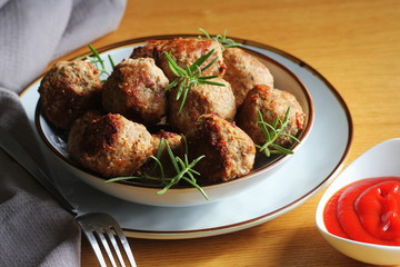 Roasted meatballs with tomato sauce , delicious meat cutlets on wooden table