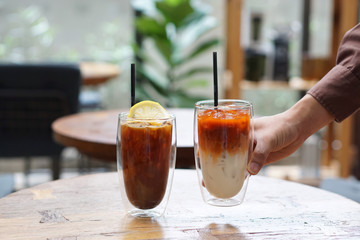 Iced milk tea and Iced coffee with orange on table and blurred background, Perfect drink for summer time.