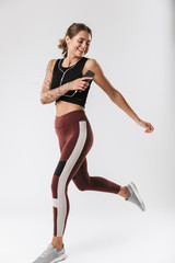 Obraz premium Image of fitness woman running and listening to music with earphones