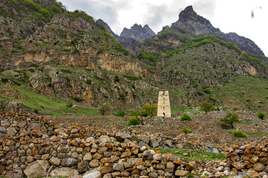 Ancient Stone Watchtower On The Background Of Mountains.
