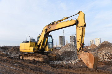 Excavator digs the ground for the foundation at construction site. Road repair, asphalt...