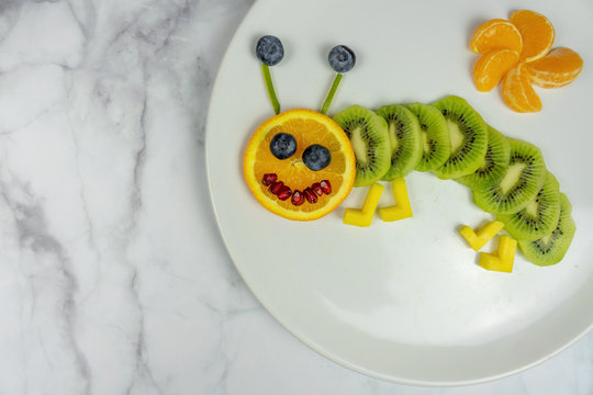 funny fruit worm on white plate healthy dessert for kids