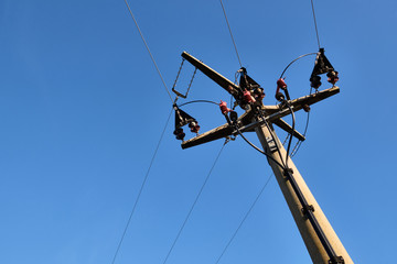 Close-up of a high voltage pylon made of concrete seen from below against blue sky with copy space...
