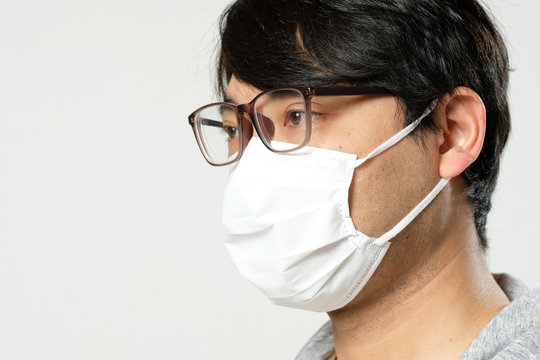 感染症予防の為に衛生マスクをしている眼鏡をかけた日本人男性の顔アップ横顔 Stock 写真 Adobe Stock