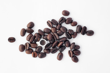 Miniature cup of coffee in loose coffee beans on white backgroud