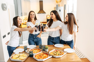 Young and happy girls have a pizza party at home