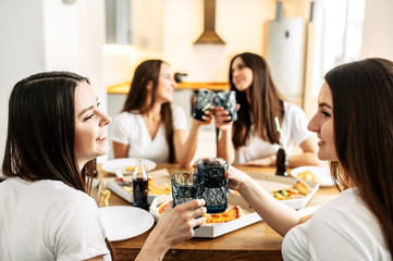 Young girls in white tshirts have lunch with pizza