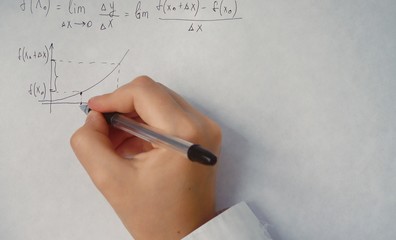 student writes trigonometric formulas on paper	
