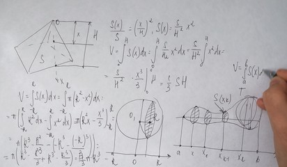student writes trigonometric formulas on paper	